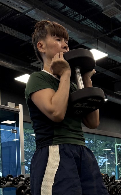 Ann holding a dumbbell at shoulder height